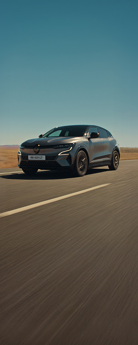 Renault Megane E-Tech, siv avtomobil, posnet od spredaj pod kotom, na odprti cesti.