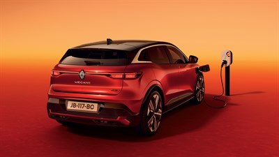 Rdeče vozilo Megane E-Tech electric, pogled od zadaj v tričetrtinskem kotu, priključeno na polnilno postajo na oranžnem ozadju.