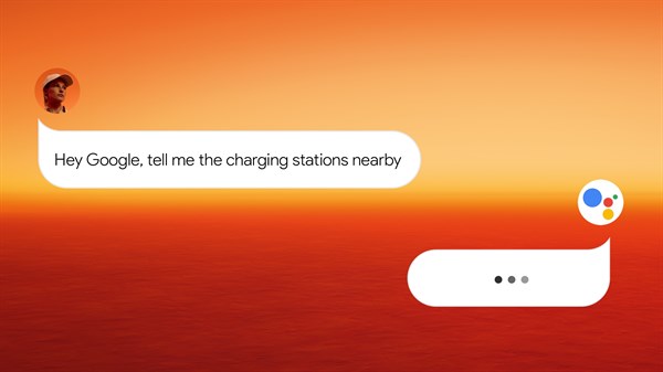 Uporabnik izgovarja ukaz 'Hey Google, povej mi, kje so bližnje polnilne postaje', Google Asistent pa pripravlja odgovor.