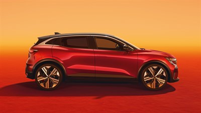 Renault Megane E-Tech Electric v profilu, rdeča barva karoserije s črno streho, postavljen na oranžno rdečem ozadju z osvetljenim nebom.