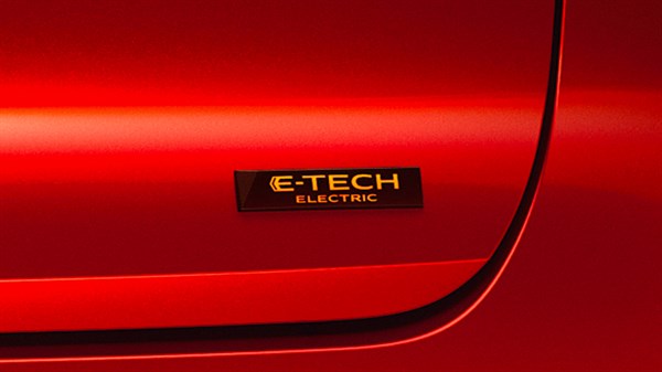 Znak E-TECH ELECTRIC na rdeči karoseriji vozila Renault.
