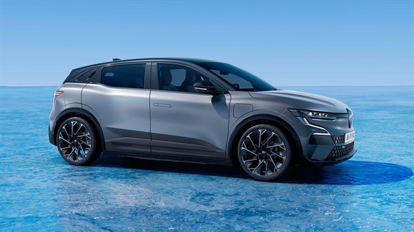 Siv Renault Megane E-Tech parkiran na ledeni površini, posnet v profilu z desne strani pod modrim nebom.