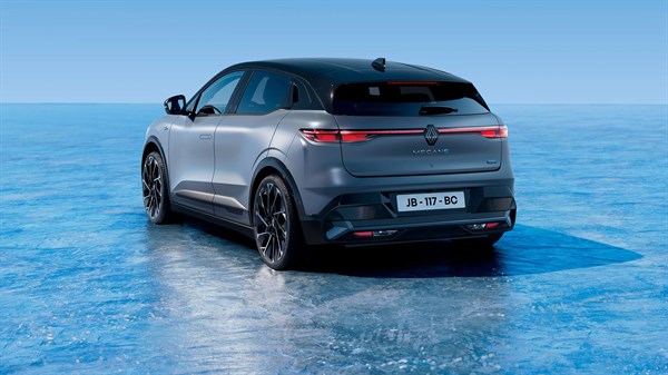Siv Renault Megane E-Tech parkiran na ledeni površini, posnet od zadaj pod kotom, z jasno vidno registrsko tablico.