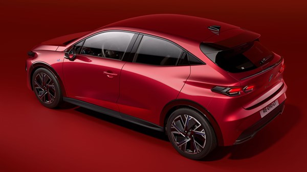 Rdeč Renault Clio v studiu, od zadaj, s poudarjenimi linijami karoserije in športnimi platišči.