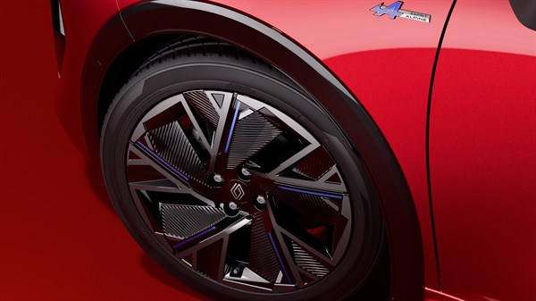 Rdeč Renault Clio, bližnji posnetek sprednjega platišča in blatnika z oznako.