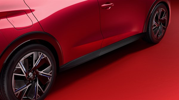 Rdeč Renault Clio, bližnji bočni posnetek med sprednjim in zadnjim kolesom v rdečem studiu.