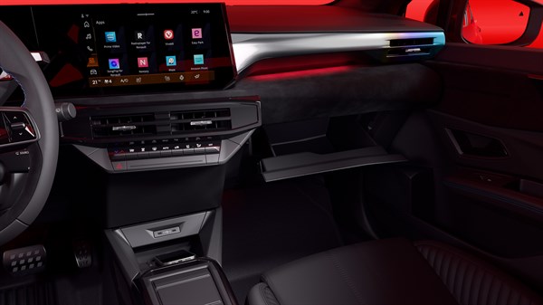 Notranjost rdečega Renault Clio; armaturna plošča z velikim zaslonom in odprtim predalom pred sovoznikom.