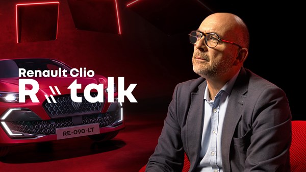 Moški v obleki pred novim Renaultom Clio v rdečem studiu.