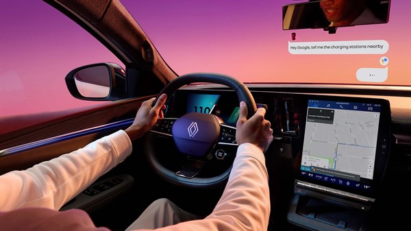 Notranjost Renault Scenic E-Tech electric z voznikom za volanom, digitalnim zaslonom openR link in prikazom navigacije na osrednjem zaslonu.