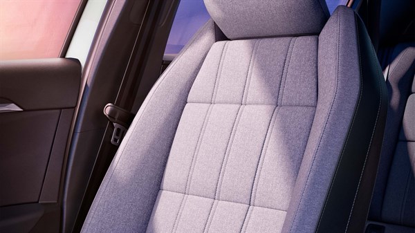 Bližnji pogled na tekstilni sedež v Renault vozilu s svetlim vzorcem in kontrastnim robom.