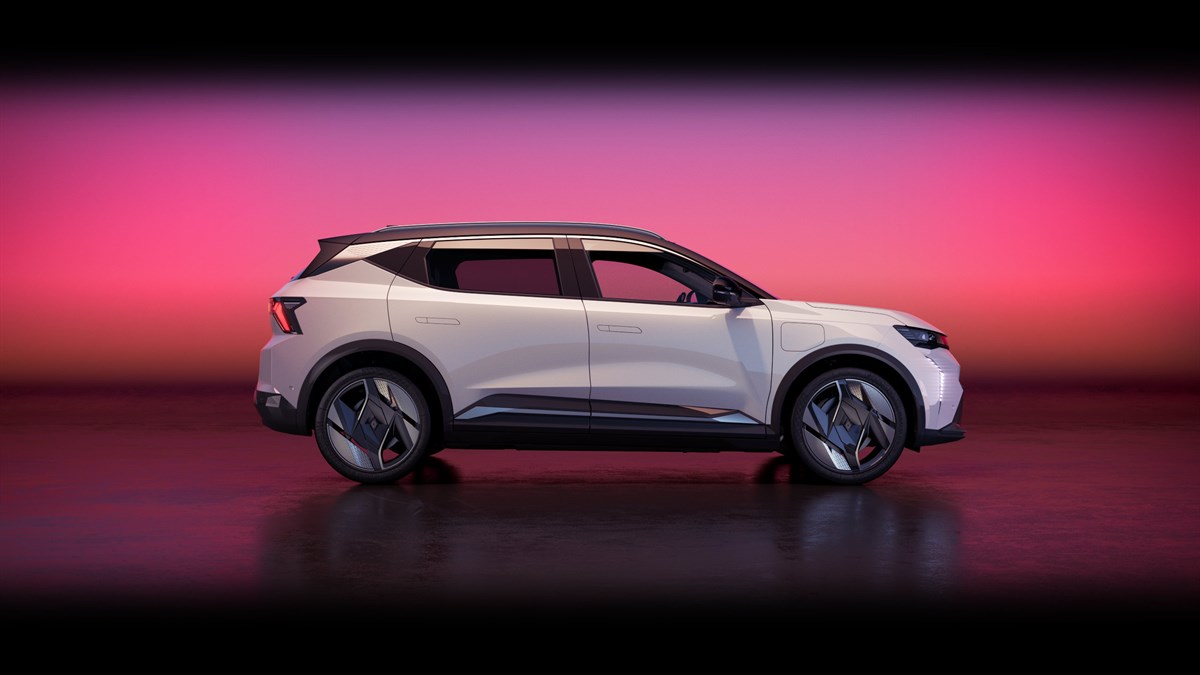 Renault Scenic E-Tech electric v srebrni barvi, pogled s strani, parkiran na odprti površini ob sončnem zahodu z rožnatim nebom v ozadju.