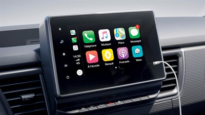 Zaslon na dotik v vozilu prikazuje uporabniški vmesnik Apple CarPlay z aplikacijami, kot so Telefon, Glasba, Zemljevidi, Sporočila, Renault, Podcasts in Waze; priklopljen je kabel za pametni telefon.

