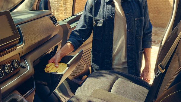 Na sliki moški odpira predal v kabini vozila Renault Traffic Van.