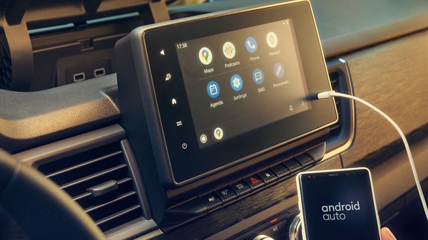 Na sliki je sredinski zaslon v vozilu Renault Traffic Van z vklopljenim Android Auto, telefon je povezan prek kabla.