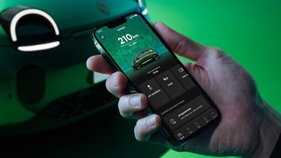Roka drži pametni telefon z aplikacijo My Renault, ki prikazuje doseg vozila Renault Twingo E-Tech electric.