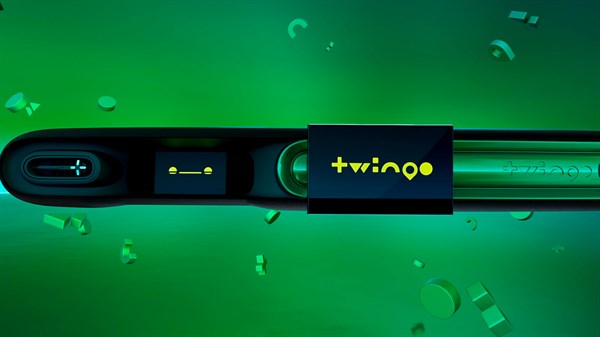 Detajl armaturne plošče vozila z osrednjim zaslonom, na katerem je prikazan napis "Twingo", na zelenem ozadju.