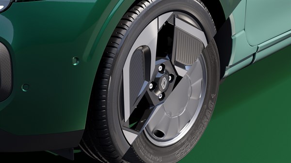 Detajl sprednjega kolesa zelenega Twingo, bližnji pogled na platišče in pnevmatiko.