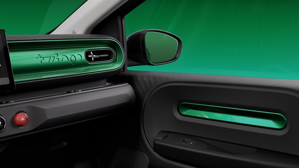 Detajl notranjosti vozila Twingo, pogled na sovoznikovo stran z zelenim dekorjem na armaturni plošči in vratnih oblogah.