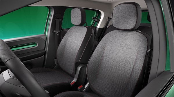 Notranjost vozila, pogled na sprednja sedeža s sivim tekstilnim oblazinjenjem in naslonjaloma za glavo.