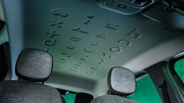 Notranjost vozila, pogled na stropno oblogo z vtisnjenimi simboli in tipografijo.