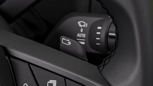 Detajl ročice ob volanu v Renault vozilu z oznakami za upravljanje brisalcev in način AUTO.