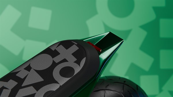 Detajl zadnjega sedeža in zadnjega dela motornega kolesa z vzorcem na oblazinjenju.