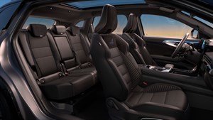 Razkošna notranjost vozila Renault Austral z usnjenimi sedeži, prostorno kabino in panoramsko streho ob sončnem zahodu.