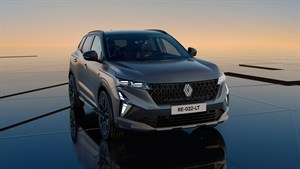 Sodoben SUV Renault Austral z dinamično obliko in LED žarometi, parkiran na odsevni površini ob sončnem zahodu.