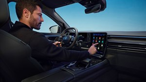 Moški upravlja osrednji zaslon na dotik v notranjosti vozila Renault Austral.