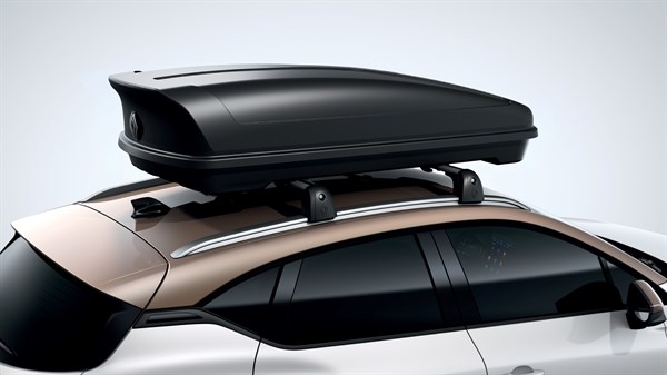 Strešni kovček nameščen na strehi avta z zlato-bronasto streho in belim spodnjim delom karoserije.