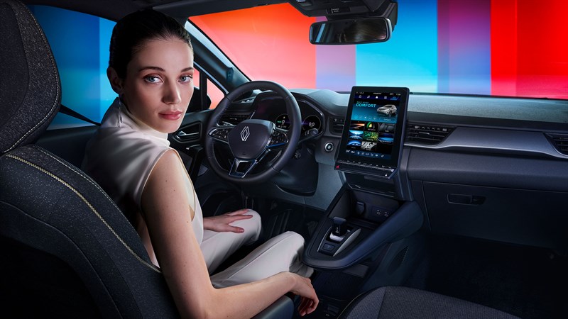 Voznica sedi v voznikovem sedežu in gleda nazaj.