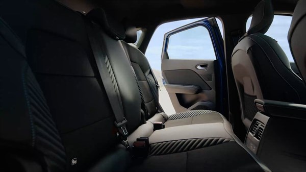 Pogled na zadnje sedeže vozila Renault Captur z odprtimi vrati, ki razkrivajo prostorno in udobno notranjost z modernimi sedeži in kakovostnimi materiali.