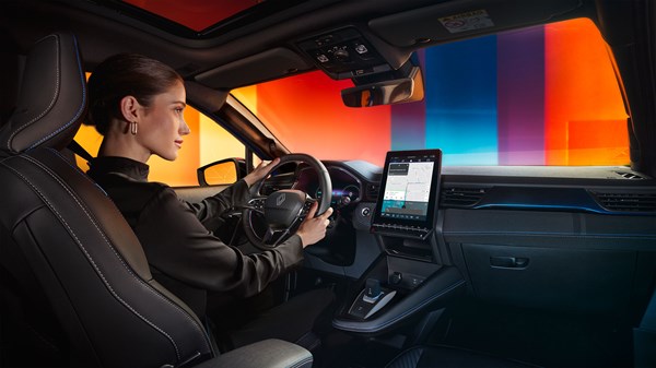 Voznica, ki uporablja navigacijski sistem v notranjosti vozila in zaslon na dotik.