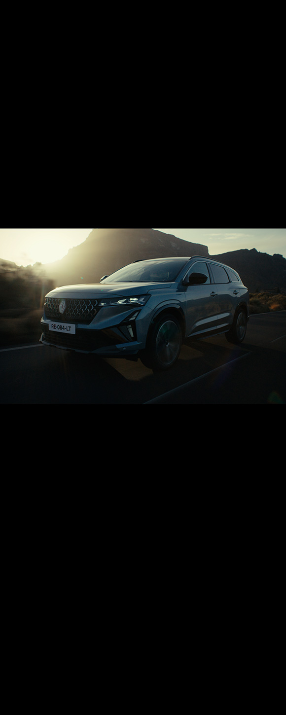 Renault Espace v svetlo modro-srebrni barvi, pogled od spredaj-levo ob sončnem zahodu, med vožnjo po naravi.