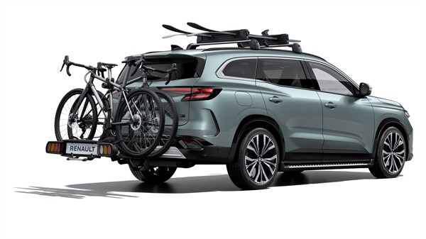 Renault Espace opremljen s strešnimi nosilci za športno opremo in nosilcem za kolesa, nameščenim na vlečni kljuki na zadnjem delu vozila.