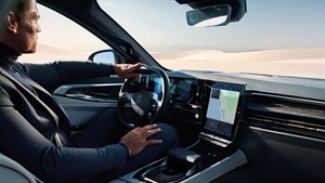 Moški v Renault Espace upravlja vozilo z vklopljeno navigacijo na sredinskem zaslonu.