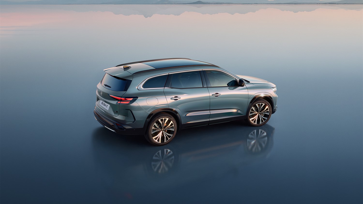 Renault Espace zadaj na odsevni površini ob sončnem zahodu.