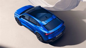 Renault Rafale v modri barvi parkiran na svetli površini z belimi platni v ozadju.