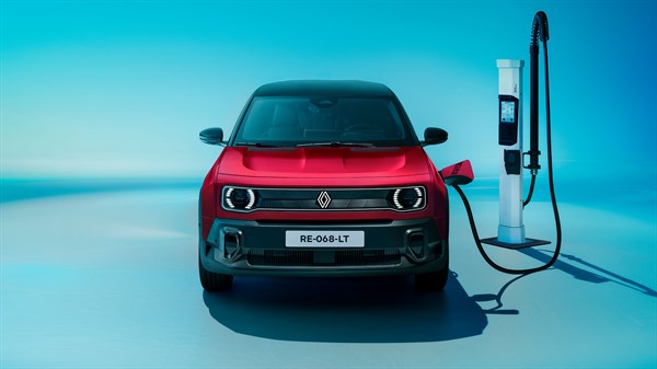 Sprednji pogled na rdeči Renault 4 E-Tech Electric z vstavljenim polnilnim kablom na polnilni postaji.