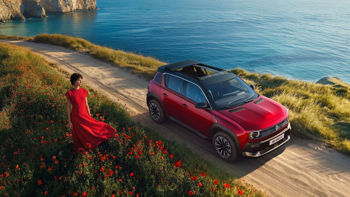 Rdeči Renault 4 s streho plein sud® na peščeni obalni poti ob morju, fotografiran od zgoraj.