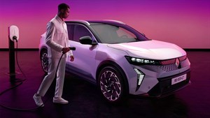 Moški priključuje polnilni kabel na Renault Scenic E-Tech electric ob polnilni postaji.