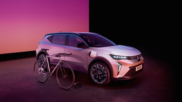 Električno kolo, priključeno na vozilo Renault Scenic E-Tech electric, ki stoji v studiu.