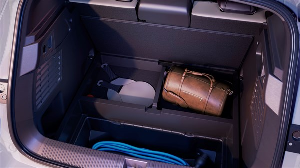 Odprt prtljažnik vozila Renault Scenic E-Tech electric s torbo in prostorom za shranjevanje pod dnom.