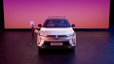 Bel Renault Scenic E-Tech electric, priključen na polnilnico, pogled od spredaj v studiu z rožnato osvetlitvijo.
