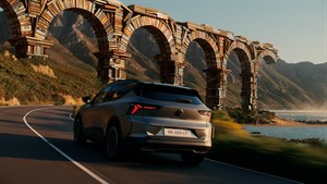 Renault Scenic E-Tech electric v vožnji po obalni cesti mimo kamnitega akvadukta.