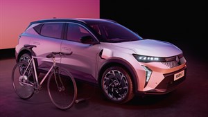 Bel Renault Scenic E-Tech electric s kolesom, sprednji tričetrtinski pogled v studiu z rožnato-vijolično osvetlitvijo.