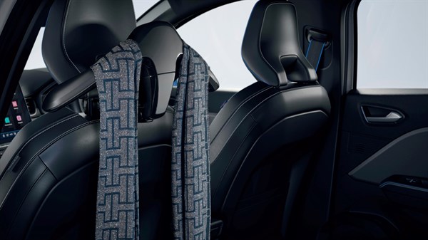 Obešalnik na katerem je obešena modro siva kartavata na zadnjem delu sedeža.