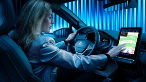 Ženska sedi za volanom Renault Symbioz in upravlja osrednji zaslon na dotik.