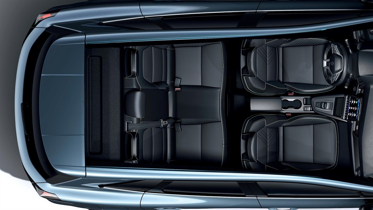 Pogled od zgoraj na notranjost Renault Symbioz s petimi sedeži in prtljažnikom, napolnjenim s kovčki in zložljivim vozičkom.