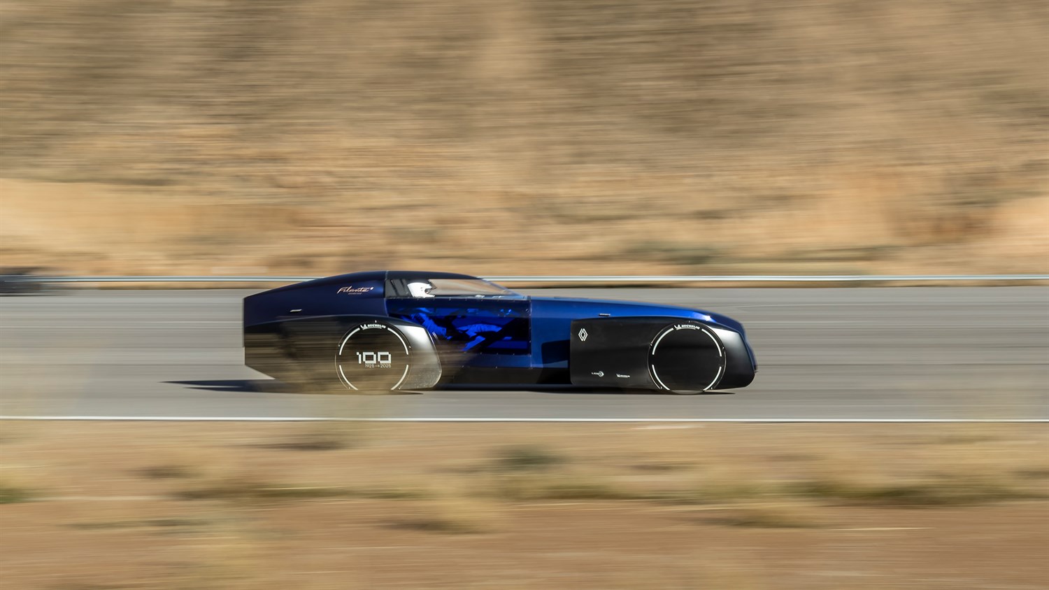 Moder Renault Filante Record 2025, med vožnjo po cesti v puščavskem okolju.